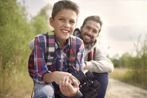 A boy along with his dad smiling at the camera
