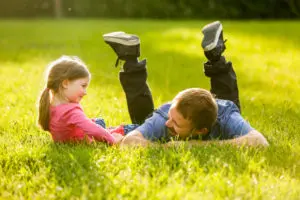 A man along with his daughter playing in a field