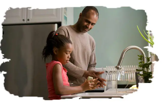 photo of a dad standing at the kitchen sink with his young daughter cooking together_edited
